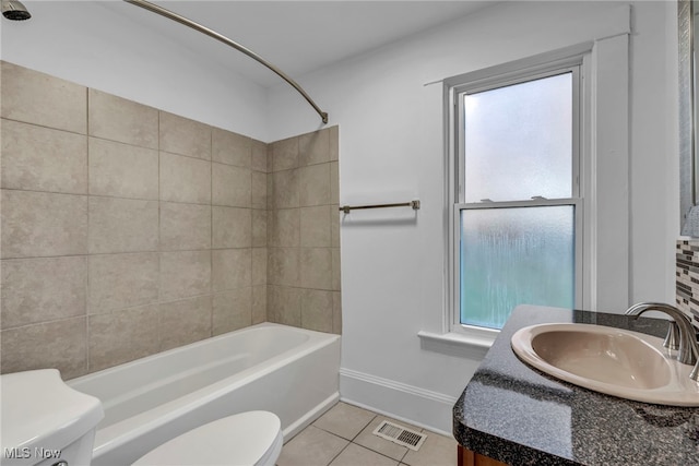 full bathroom featuring tile patterned flooring, tiled shower / bath combo, toilet, and vanity