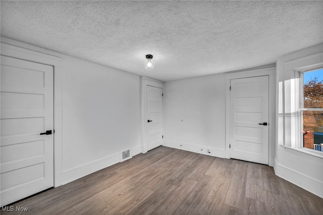 spare room with a textured ceiling and hardwood / wood-style flooring