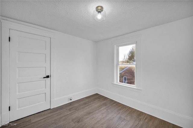 unfurnished room with wood-type flooring and a textured ceiling