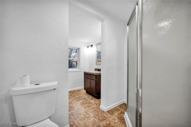 bathroom featuring tile patterned floors, a shower with door, vanity, and toilet