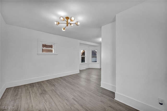 empty room featuring hardwood / wood-style floors and a chandelier