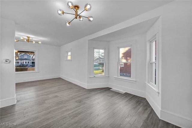 unfurnished room featuring hardwood / wood-style floors and an inviting chandelier