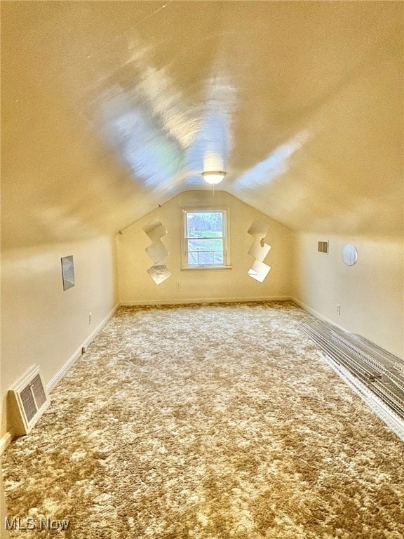 bonus room with a textured ceiling, carpet, and vaulted ceiling