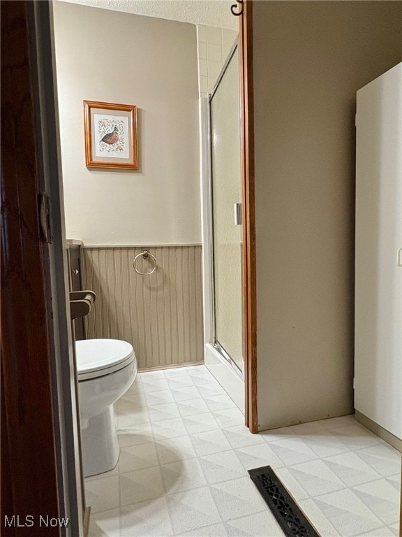 bathroom featuring toilet and an enclosed shower