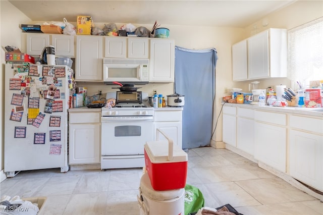 kitchen featuring white appliances and white cabinetry