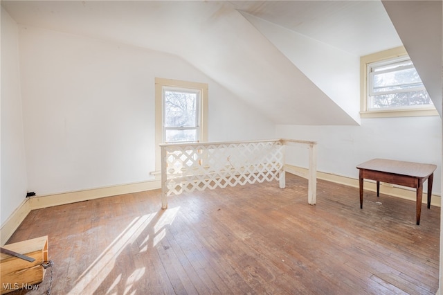 bonus room with wood-type flooring and vaulted ceiling