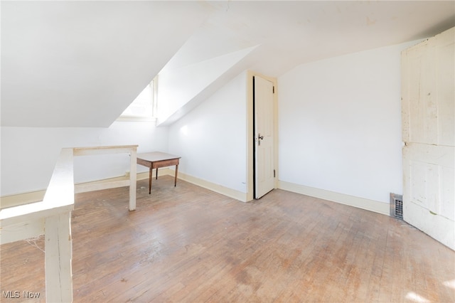 additional living space featuring light hardwood / wood-style flooring and lofted ceiling