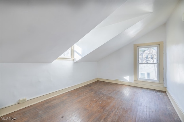 bonus room featuring vaulted ceiling with skylight and dark hardwood / wood-style flooring