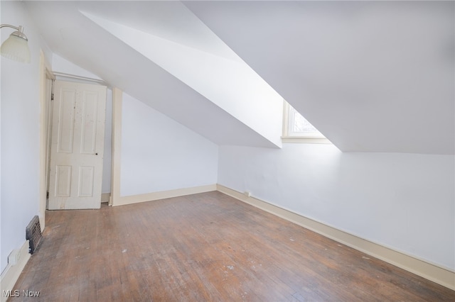 additional living space featuring vaulted ceiling and hardwood / wood-style flooring