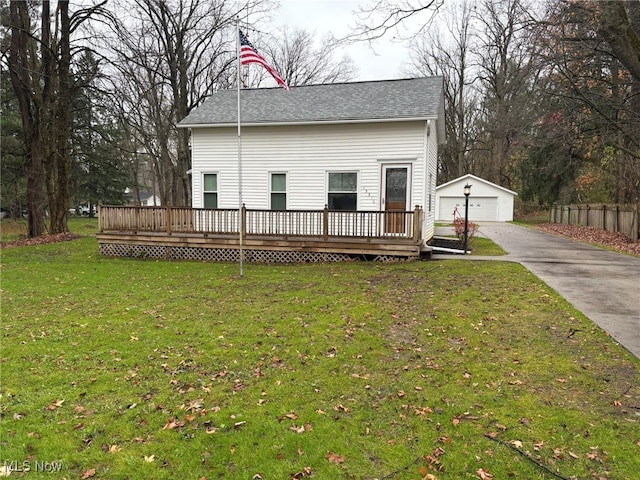 view of front of home with an outdoor structure, a deck, a front lawn, and a garage