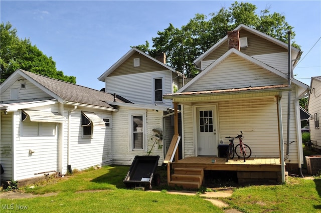 rear view of property with a lawn, a wooden deck, and cooling unit