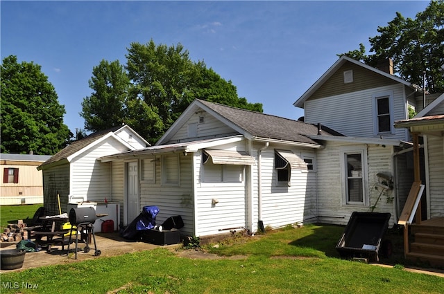 rear view of property featuring a lawn and a patio area