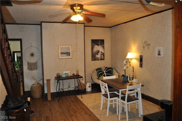 tiled dining area featuring ceiling fan and ornamental molding