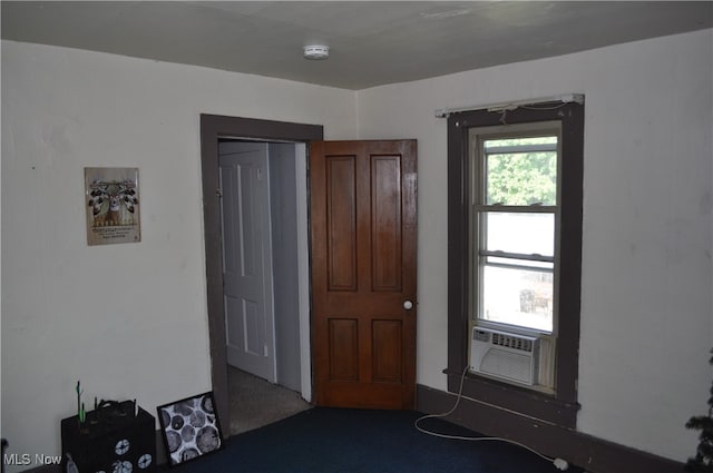 unfurnished bedroom featuring cooling unit and carpet