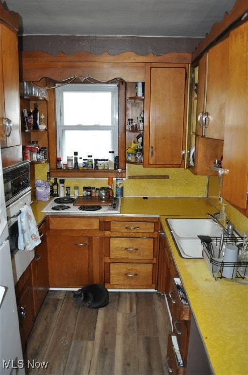 kitchen featuring white appliances, dark wood-type flooring, and sink