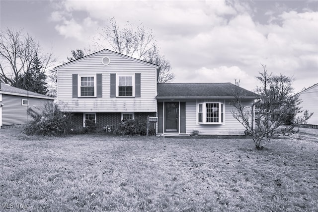 tri-level home with a front lawn