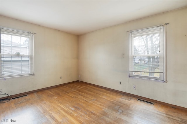 spare room featuring plenty of natural light and light wood-type flooring