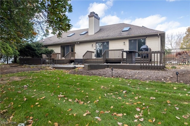 rear view of property featuring a lawn and a wooden deck