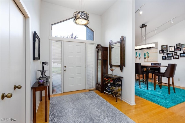 entryway with high vaulted ceiling and hardwood / wood-style flooring