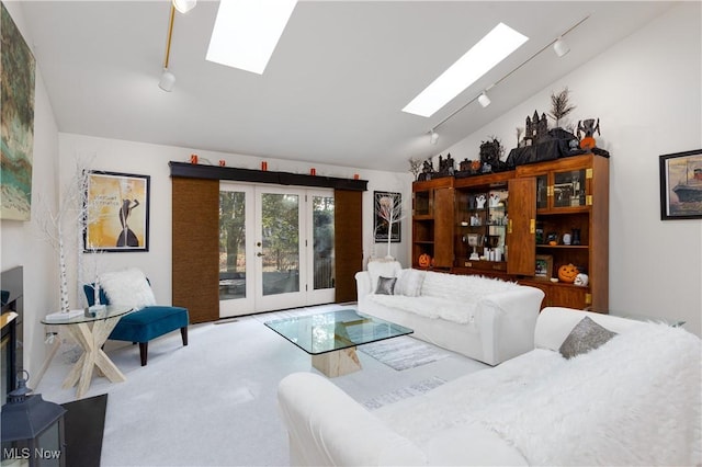 carpeted living room with lofted ceiling with skylight and french doors