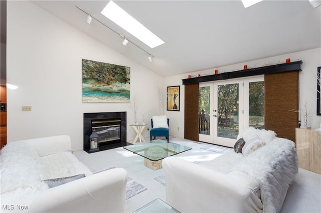 living room with lofted ceiling with skylight and french doors