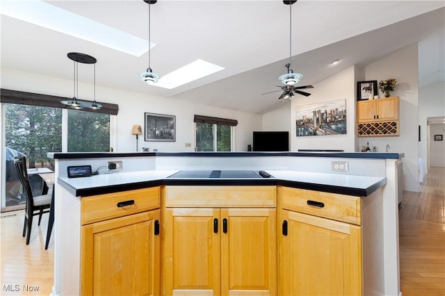 kitchen with black electric cooktop, lofted ceiling with skylight, light hardwood / wood-style flooring, and a wealth of natural light