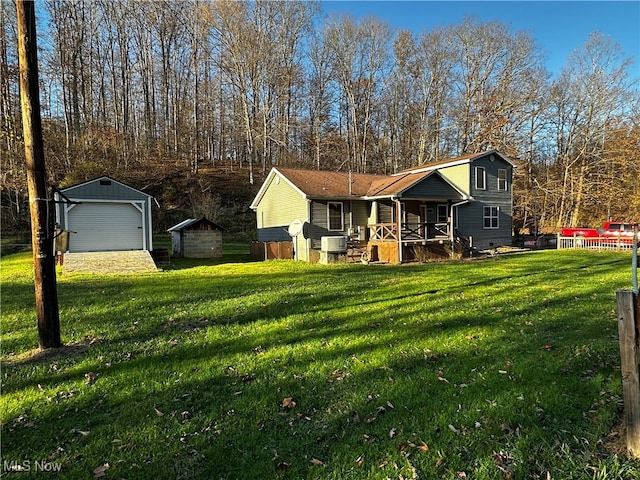 view of front of property with covered porch, a garage, an outbuilding, and a front lawn