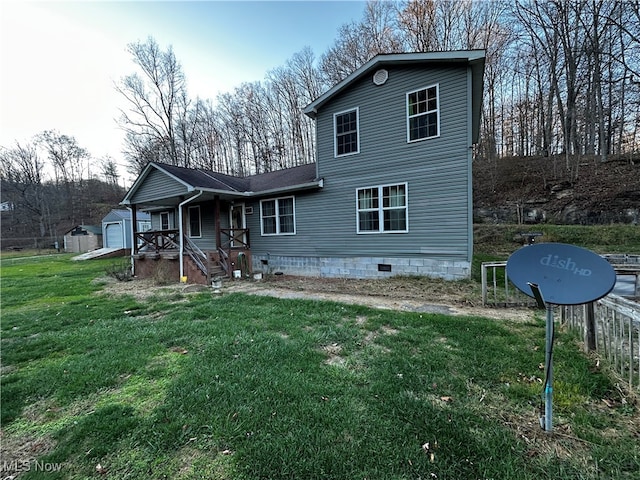 rear view of house featuring a lawn, a garage, and an outdoor structure