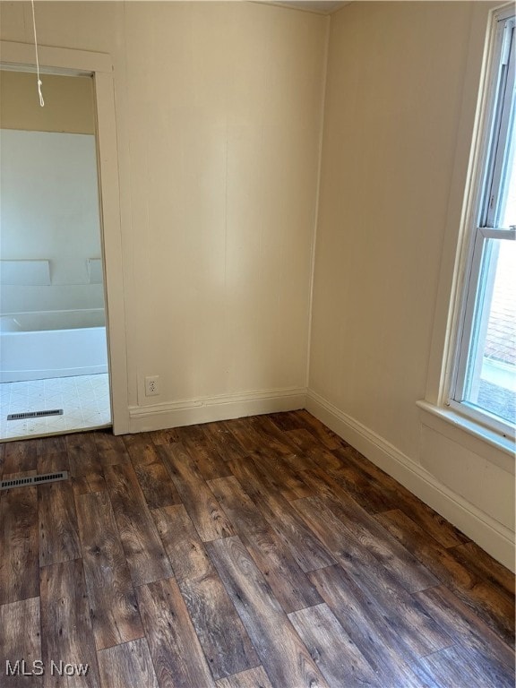 unfurnished room with dark wood-type flooring