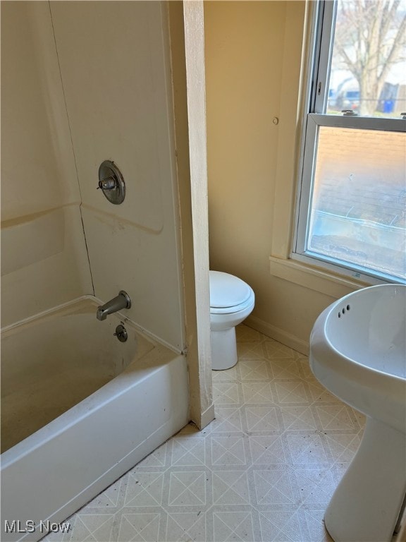 bathroom with shower / tub combination, tile patterned flooring, and toilet