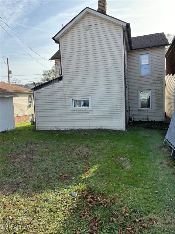 back of property with a lawn