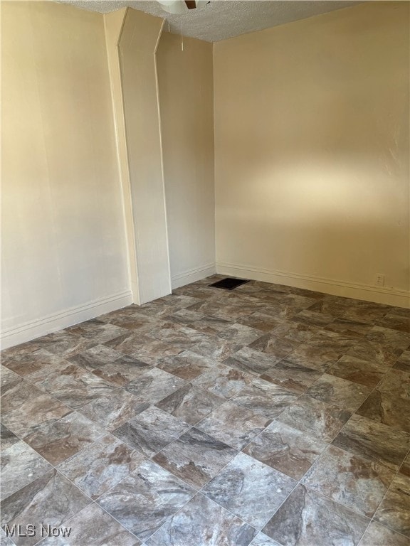 unfurnished room featuring a textured ceiling and ceiling fan