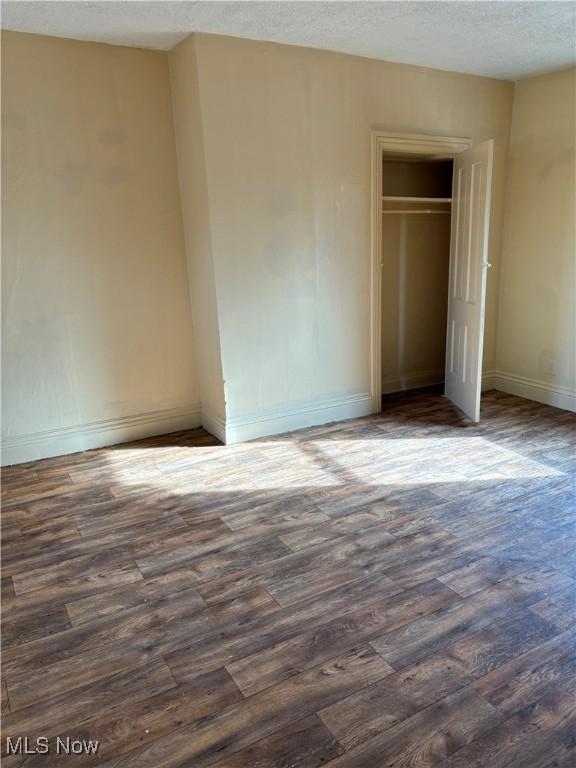 1013 Saint George, East Liverpool, OH 43920 - unfurnished bedroom with dark wood-style flooring, a closet, and a textured ceiling