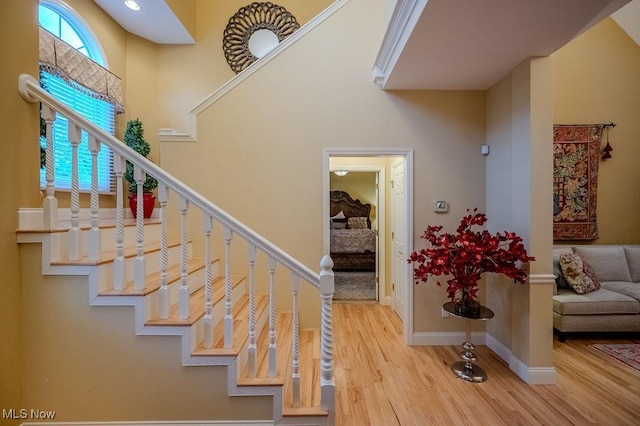 staircase featuring wood finished floors and baseboards