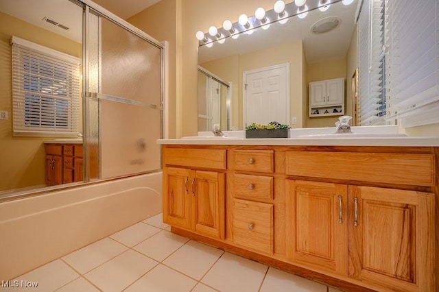 full bathroom with double vanity, combined bath / shower with glass door, a sink, and tile patterned floors