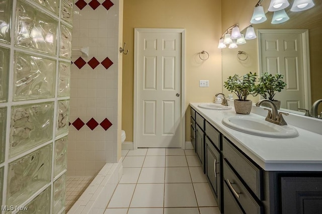 full bathroom featuring double vanity, walk in shower, a sink, and tile patterned floors