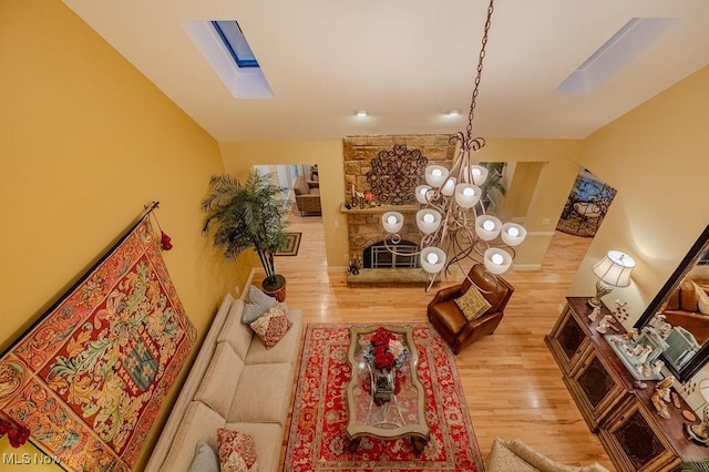 living area featuring light wood-style floors and vaulted ceiling with skylight