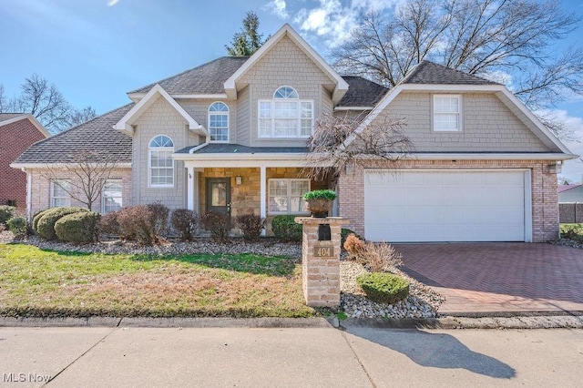 view of front of house with a garage, a porch, decorative driveway, and brick siding