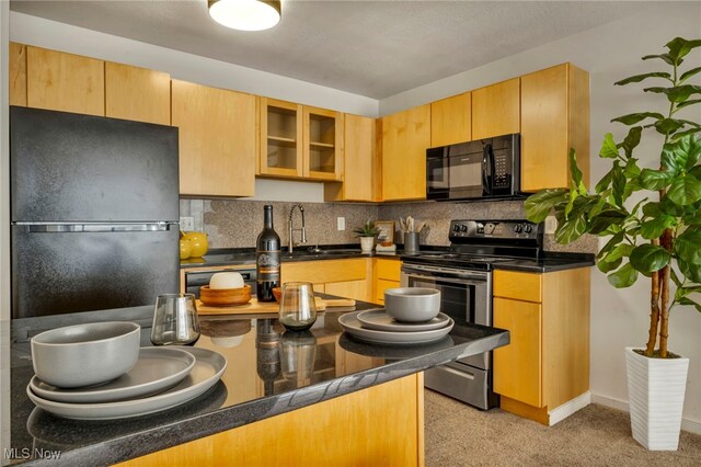 kitchen featuring sink, backsplash, and black appliances