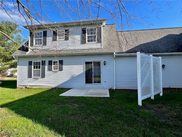 back of property with a patio area and a yard