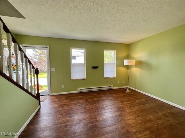 spare room with dark wood-type flooring, a baseboard radiator, and a textured ceiling