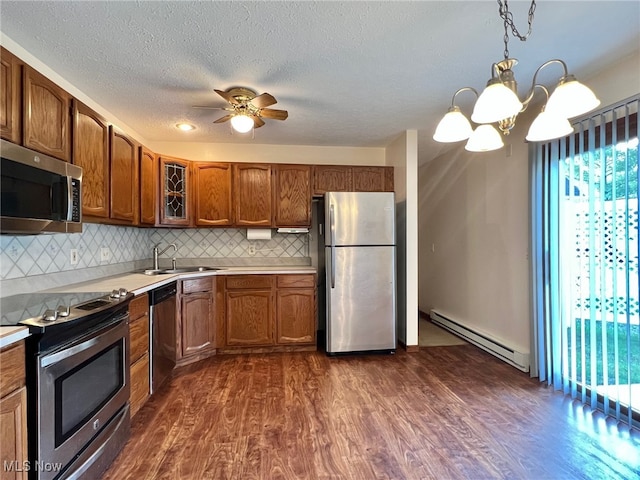 kitchen with baseboard heating, sink, stainless steel appliances, and dark hardwood / wood-style floors