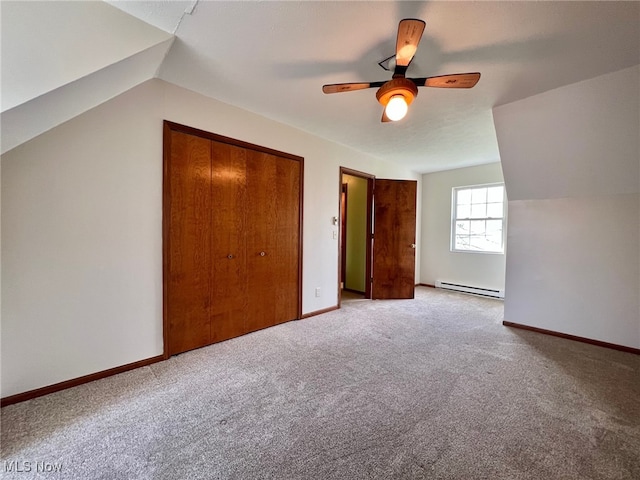 unfurnished bedroom featuring carpet, lofted ceiling, ceiling fan, a baseboard radiator, and a closet