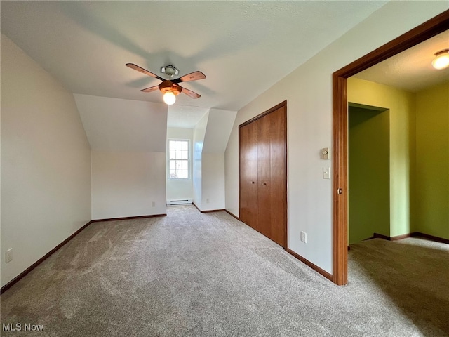 additional living space with carpet flooring, a baseboard radiator, ceiling fan, and lofted ceiling