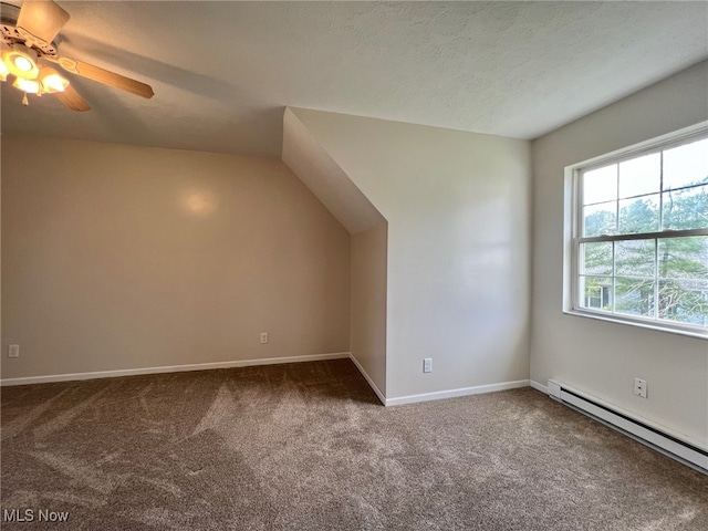 additional living space with carpet, a textured ceiling, vaulted ceiling, ceiling fan, and a baseboard radiator