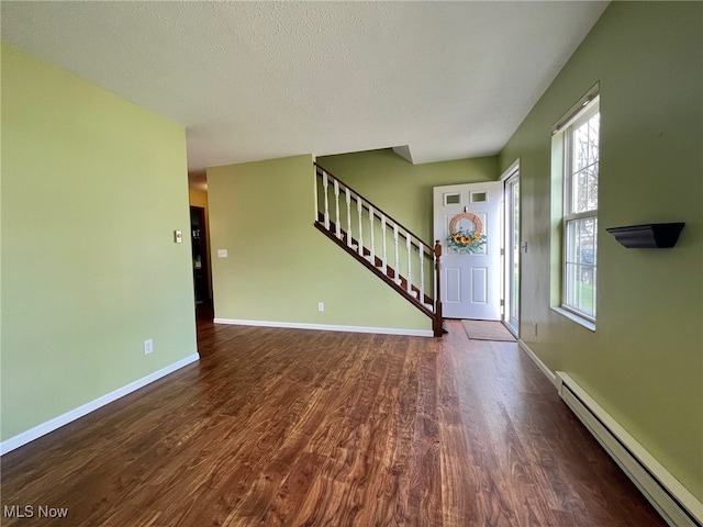 entrance foyer with a textured ceiling, baseboard heating, and dark wood-type flooring