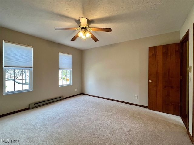 carpeted spare room featuring a textured ceiling, ceiling fan, and baseboard heating