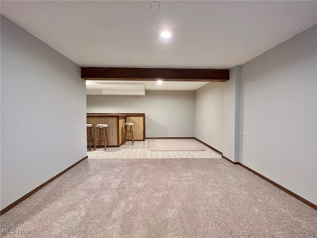 empty room with light carpet and beamed ceiling