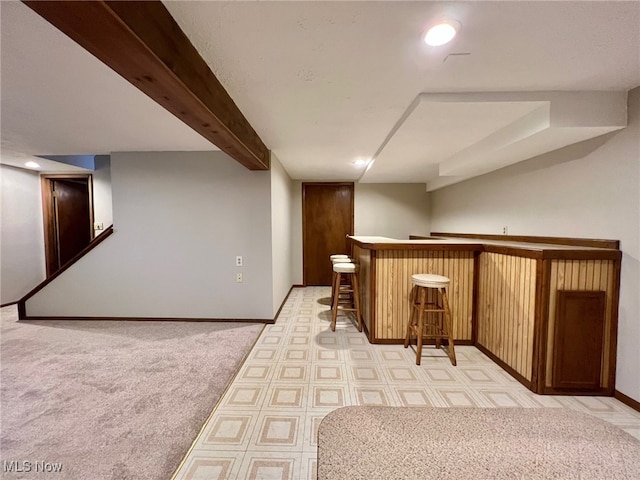 bar with light carpet and beam ceiling