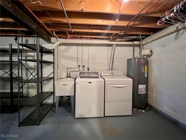 basement featuring washer and dryer, sink, and water heater